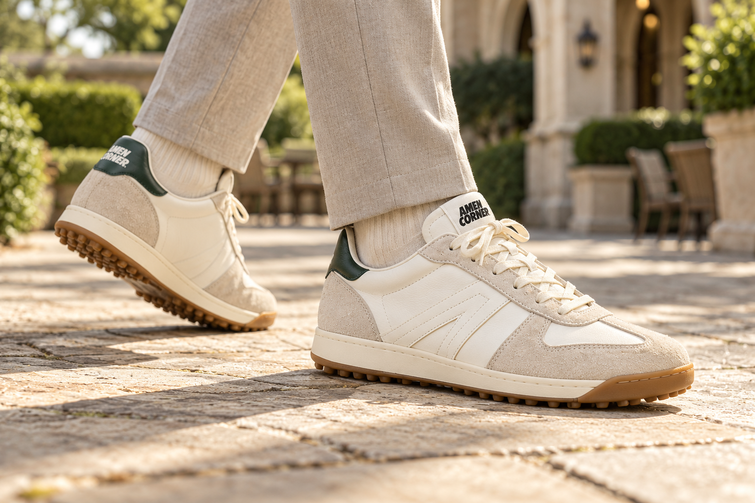 Model walking in ivory and forest green AMEN CORNER Golf Sneaker HB19 shoes, close view of the feet